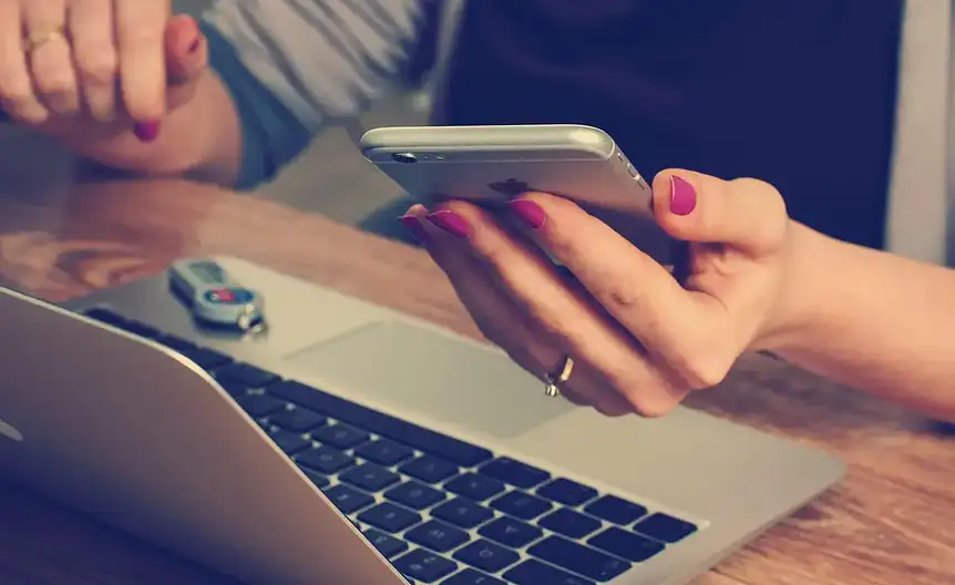 Osoba pracująca na laptopie siedząc na kanapie